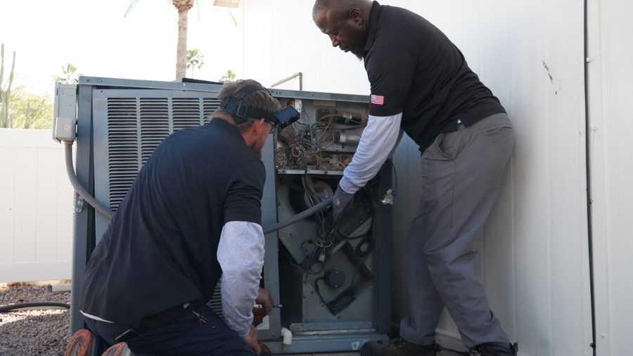 Technicians repairing a residential packaged heating system to restore reliable home comfort during the heating season.