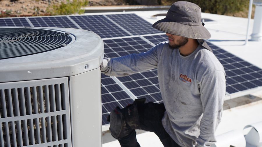 HVAC tech installing AC unit.