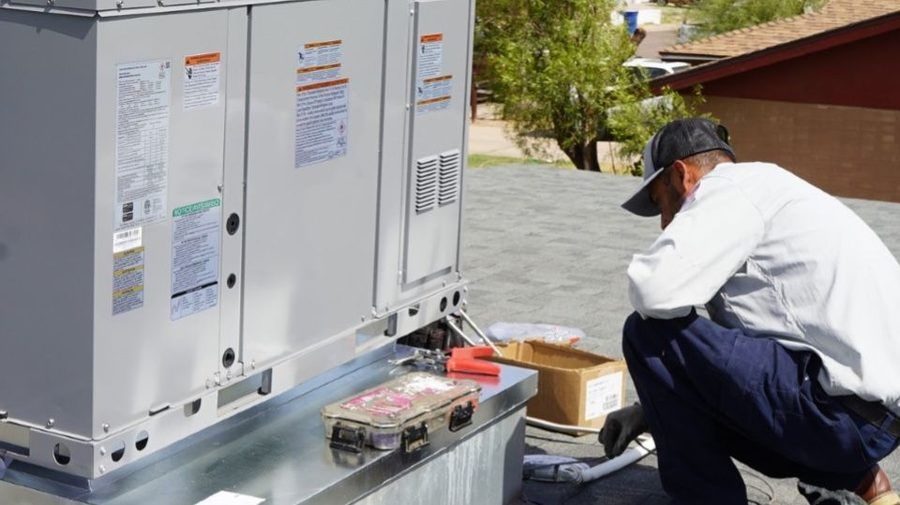 HVAC tech installing HVAC unit.