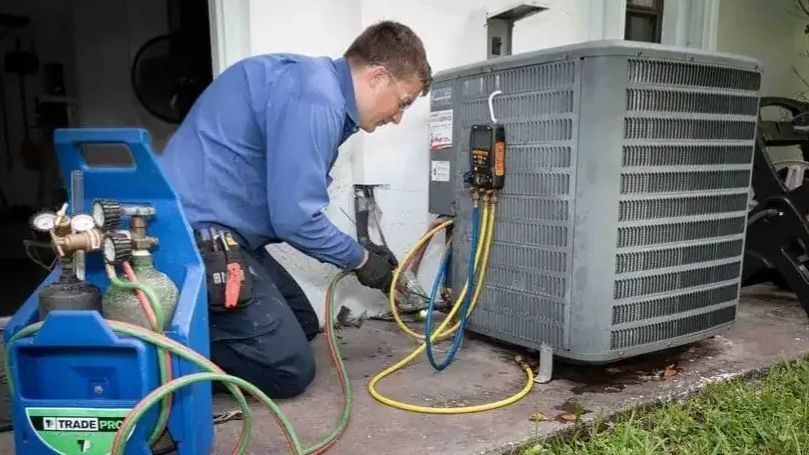 Professional HVAC technician performing air conditioning maintenance on an outdoor AC unit to improve system performance and efficiency.
