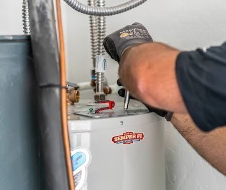 technician adjsuting water heater.
