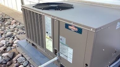 Outdoor residential heat pump installed on a concrete pad beside a home for efficient year-round heating and cooling.