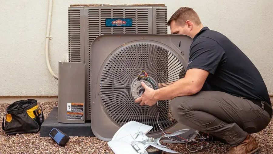 HVAC tech performing routine maintenance on AC unit.