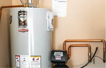 Residential hot water heater with copper supply lines and a control valve in a utility area, with installation stickers on the tank.