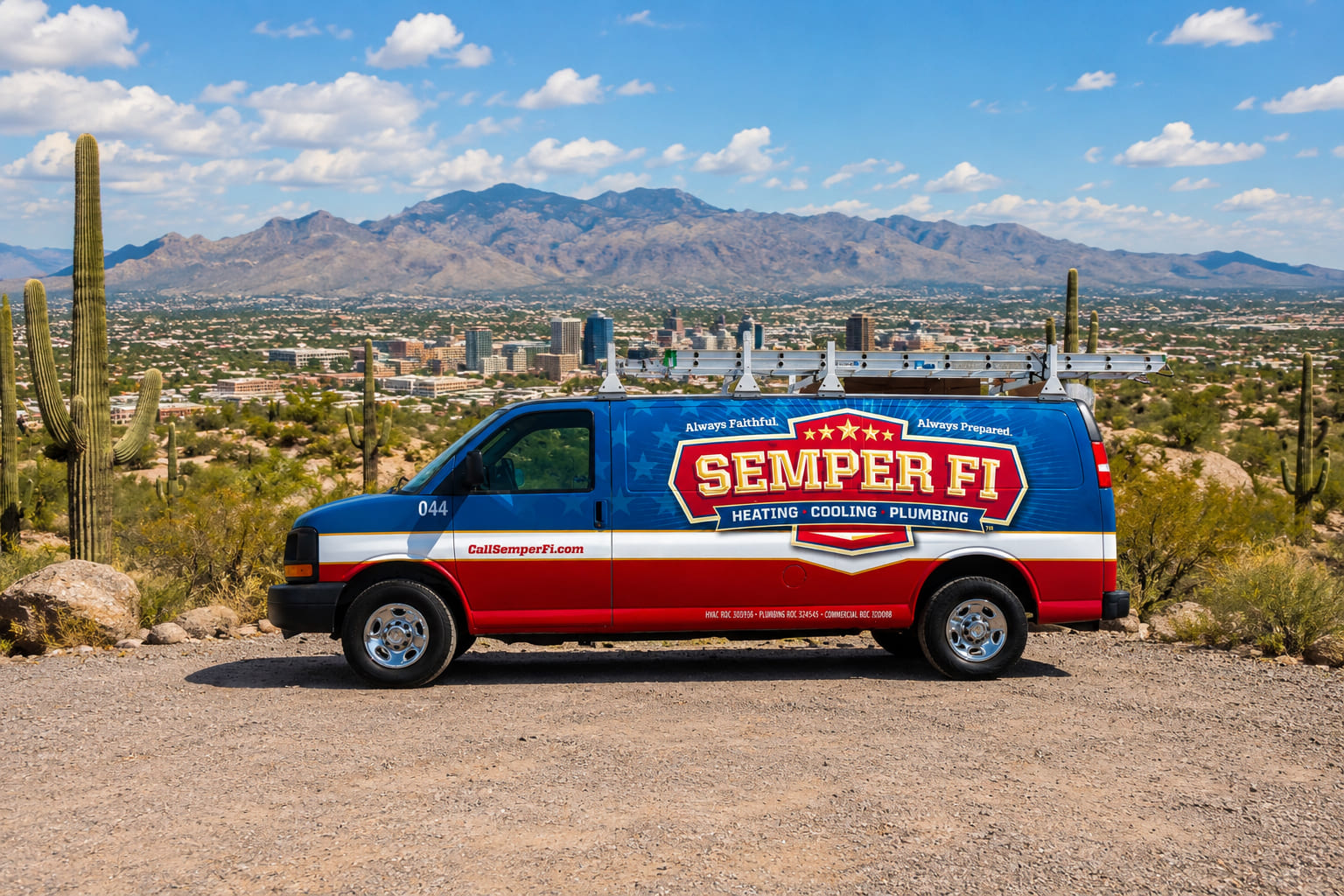 Semper Fi service van on a gravel lot with desert landscape, cacti, and a distant city and mountains.