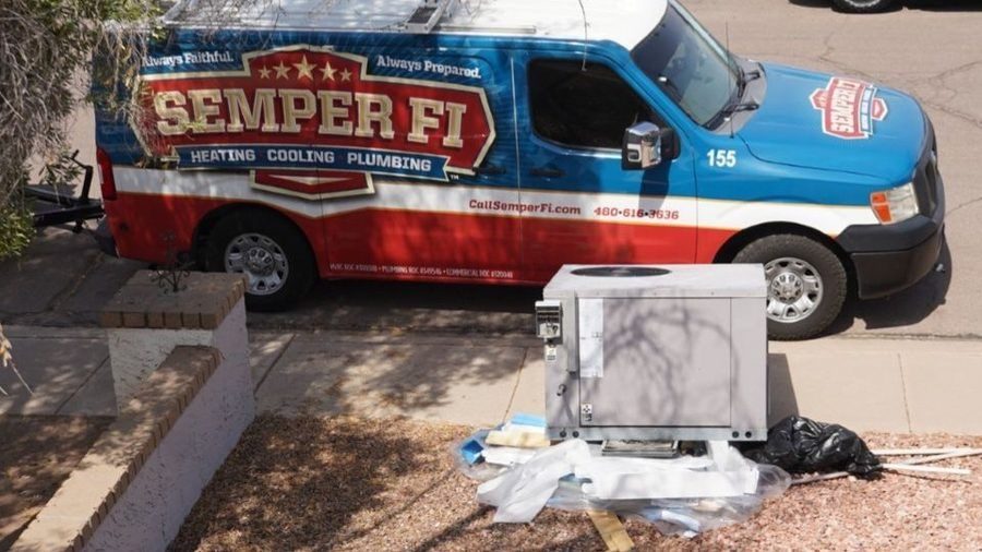 Semper van parked in front of an HVAC with a heat pump installed.