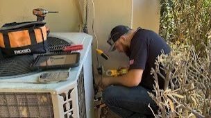 HVAC tech repairing heating unit.