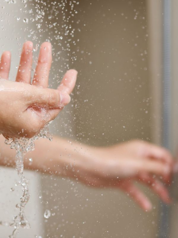 A,woman,uses,hand,to,measure,the,water,temperature,from