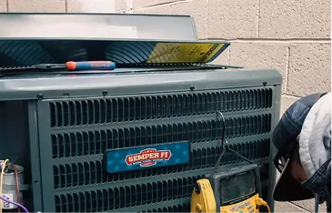 Outdoor air conditioning condenser unit on a service scene, with a blue Semper Fi label, a screwdriver on top, and a yellow multimeter nearby.