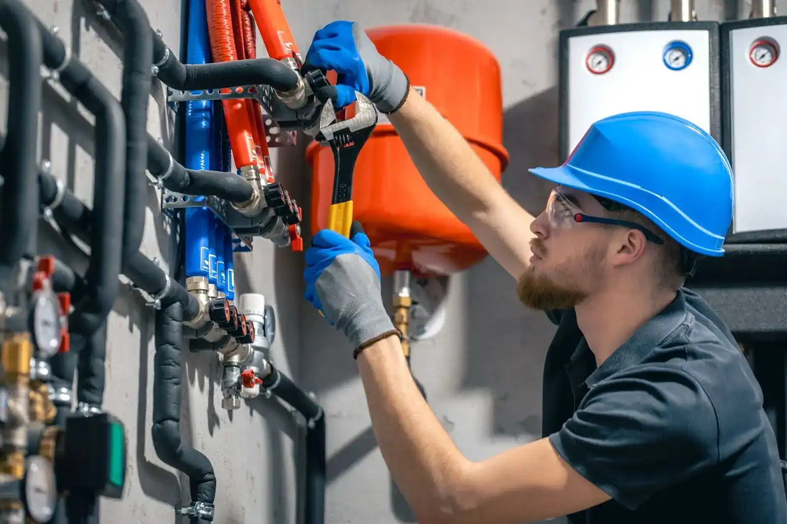 HVAC technician adjusting heating system pipes with a wrench during residential furnace repair